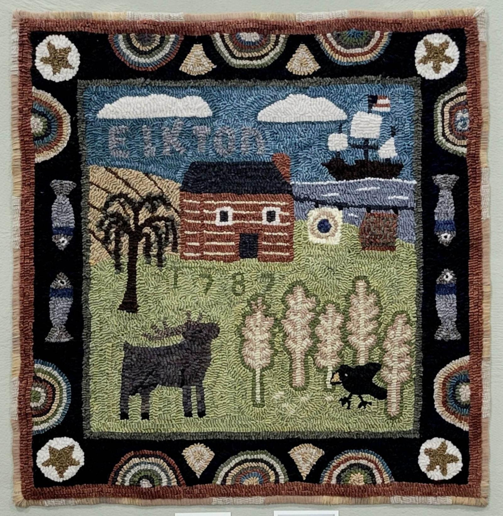 A traditional wool rug hooked rug created using hand-dyed wool on linen. The design depicts a daily scene in early Elkton, established in 1787. Fishing and wheat crops, the daily wash on the line outside the log cabin, a view of the Elk River in the background where a ship sails by. The design uses many traditional techniques and motifs. The piece is on display in Elkton at the Historical Society.