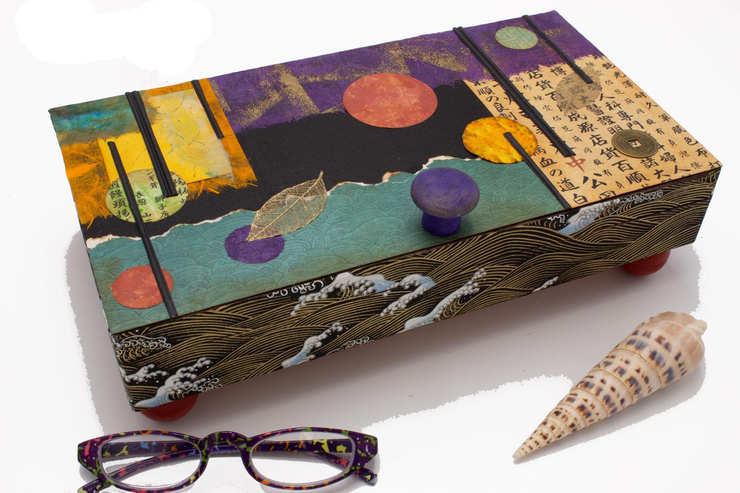 Altered wooden cigar box, collage with rice/other natural fiber paper, ink and acrylic paint. Wooden knob and feet.  Holds jewelry, chopsticks, takeout menus, keepsakes.  Depending on size/depth of box, there are removable dividers.