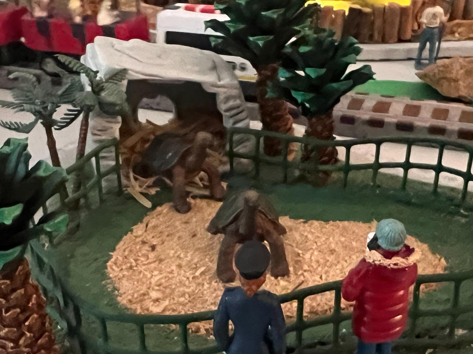  A Miniature World of Recycled Wonders

This exhibit, though small in scale, is a testament to imaginative reuse and highlights how everyday discarded items can find new life as creative components. It encapsulates a whimsical, handcrafted aesthetic, clearly designed with a playful spirit in mind. 
Core Exhibit Elements:
     Animal Housing: The central dwelling for the exhibit's imagined inhabitants is a discarded kid's meal Flintstone's hut. This instantly recognizable, pre-formed structure lends a charmingly anachronistic and cartoonish touch to the scene, suggesting a playful, perhaps even prehistoric, environment for its tiny occupants. Its previous life as a fast-food toy adds a layer of nostalgia and accessibility to the display.
     Enclosure Fencing: Complementing the hut, the enclosure's fencing is ingeniously crafted from a recycled wire basket. The open weave of the basket provides a permeable boundary, allowing viewers to peer into the miniature world while maintaining the illusion of a contained habitat. The utilitarian origin of the basket juxtaposes nicely with the more fantastical hut, grounding the display in a sense of resourceful creativity.
     Natural Elements: To bring a touch of the outdoors into this miniature diorama, pinecones (half-eaten by squirrels) are strategically placed. These natural elements introduce texture and an organic feel, while the detail of them being "half-eaten" adds a touch of authenticity and perhaps even a subtle narrative of small creatures interacting with their environment. Their presence subtly bridges the gap between the artificial components and a more naturalistic setting.
     Figurines: Populating this tiny world are various plastic people and plastic animals. These mass-produced toys serve as the inhabitants of the exhibit, adding scale and allowing for countless imaginative scenarios. Their generic nature encourages viewers to project their own stories onto the scene, making the exhibit highly interactive and engaging, especially for younger audiences. The choice of plastic figurines reinforces the theme of utilizing readily available materials.
     Base: The entire miniature landscape is supported by a sturdy plywood base. This fundamental component provides a stable and flat surface for the exhibit, allowing for easy display and manipulation of the individual elements. Its simple, unadorned nature ensures that the focus remains on the creative arrangement of the other components.
     Decorations: Unifying and enhancing the overall aesthetic is the liberal use of acrylic paint. This versatile medium allows for the application of color, texture, and detail to various components, transforming their original appearance and bringing the entire scene to life. The paint can be used to add vibrant hues to the plastic elements, create naturalistic tones on the pinecones, or even subtly alter the appearance of the hut and fencing, tying all the disparate parts into a cohesive and visually appealing display.

Through the clever repurposing of common household items and discarded toys, this Galapagos exhibit offers a unique and charming interpretation of an ecosystem. It champions the principles of recycling and creative problem-solving, turning what might otherwise be waste into an engaging and educational display
