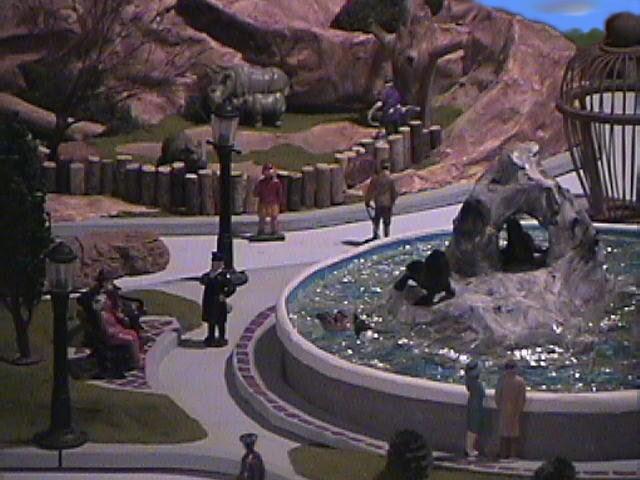 Key Components and Materials:

Rock Formations: The rugged and textured rock formations, crucial for providing the sea lions with a natural-looking habitat, were expertly fashioned from paper mache. This material allowed for the creation of organic, varying shapes and a lightweight structure.

Water Feature: The illusion of shimmering, deep water was achieved through the careful application of epoxy. This resin provides a glossy, transparent, and durable finish, perfectly mimicking the look of an active sea lion pool.
Natural Elements: To bring a sense of organic authenticity to the exhibit, a variety of natural elements were incorporated. 

These included:
     Pine Bark: Utilized to add texture and depth to the landscape, simulating rocky outcrops or ground cover.
     Cut Sticks and Branches: Strategically placed to represent driftwood, fallen logs, or perches, enhancing the natural appeal     of the environment.
     Sumac Tree Buds: Ingeniously repurposed to serve as miniature trees, lending a touch of botanical detail and scale to the exhibit.

Figurines:    A diverse collection of figurines populates the exhibit, adding life and narrative:
      Plastic Animals: Representing the star inhabitants, the sea lions themselves, as well as other potential marine or coastal wildlife.
     Die-Cast Antique Lead Figurines: These add a unique historical or whimsical touch, potentially depicting human visitors or other elements of interest.
     Plastic Figurines: Further diversifying the inhabitants and elements within the diorama.
Base Structure: The entire exhibit is robustly supported by a multi-part base:
     Recycled Plastic Container: This likely forms the core of the water feature or a central structural element, demonstrating an eco-conscious approach to construction.
     Plywood Base: Providing a sturdy and flat foundation upon which the entire exhibit is constructed, ensuring stability and ease of display.
Other Found Objects: The creative use of "found objects" highlights a resourceful and artistic approach to model-making. These unlisted items likely contribute unique textures, details, or structural elements that enhance the overall realism and charm of the exhibit.

This "Seal Lion Exhibit" is a testament to imaginative material usage and careful construction, resulting in a compelling and detailed representation of a marine environment.
