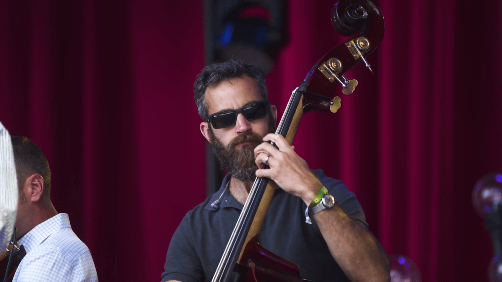 Man in sunglasses performs on an upright bass
